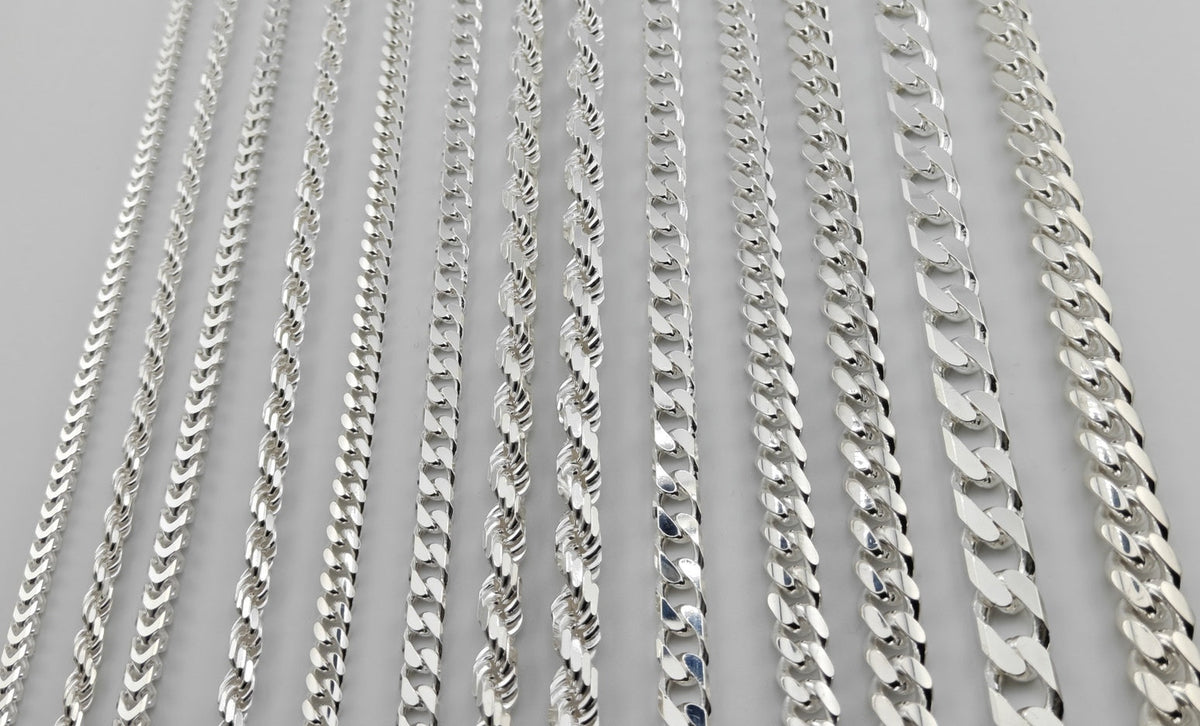 All thirteen Neviera silver chain widths laid side by side, from 3,8 mm Franco to 12,2 mm Cuban link, in solid 925 sterling silver