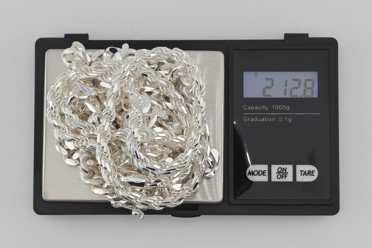 Several Neviera solid 925 sterling silver chains weighed together on a jeweller's scale, reading 212,8 g