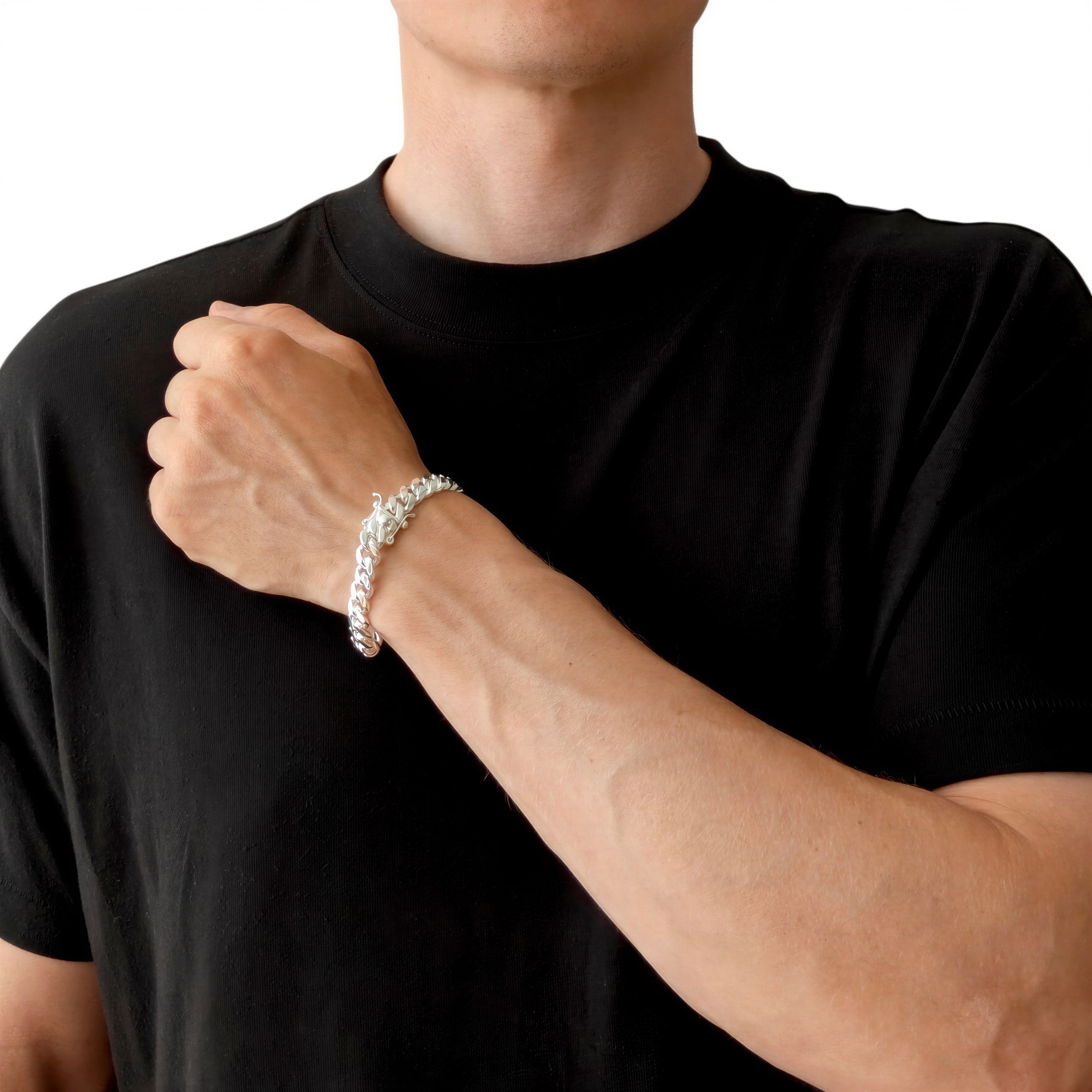 Neviera Cuban link chain bracelet — Italian-made 925 sterling silver, 9,1mm width. Lifestyle photograph on model wearing the bracelet with a black crew-neck t-shirt on a neutral background. Neviera specializes in high-quality Italian-made 925 silver chain necklaces and bracelets.