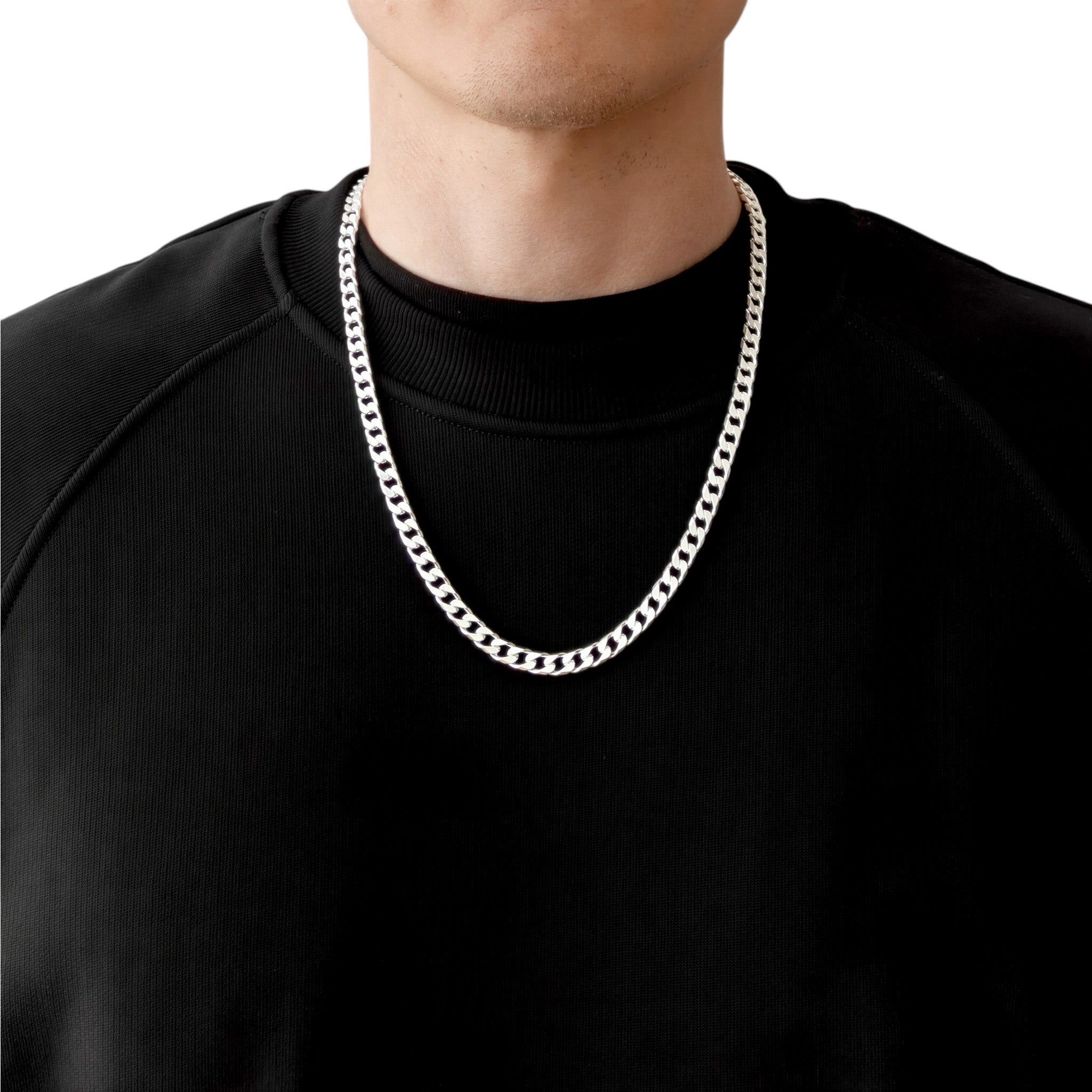 Neviera curb link chain necklace — Italian-made 925 sterling silver, 60cm length, 6,4mm width. Lifestyle photograph on model wearing the chain with a black crew-neck sweatshirt on a neutral background. Neviera specializes in high-quality Italian-made 925 silver chain necklaces and bracelets.
