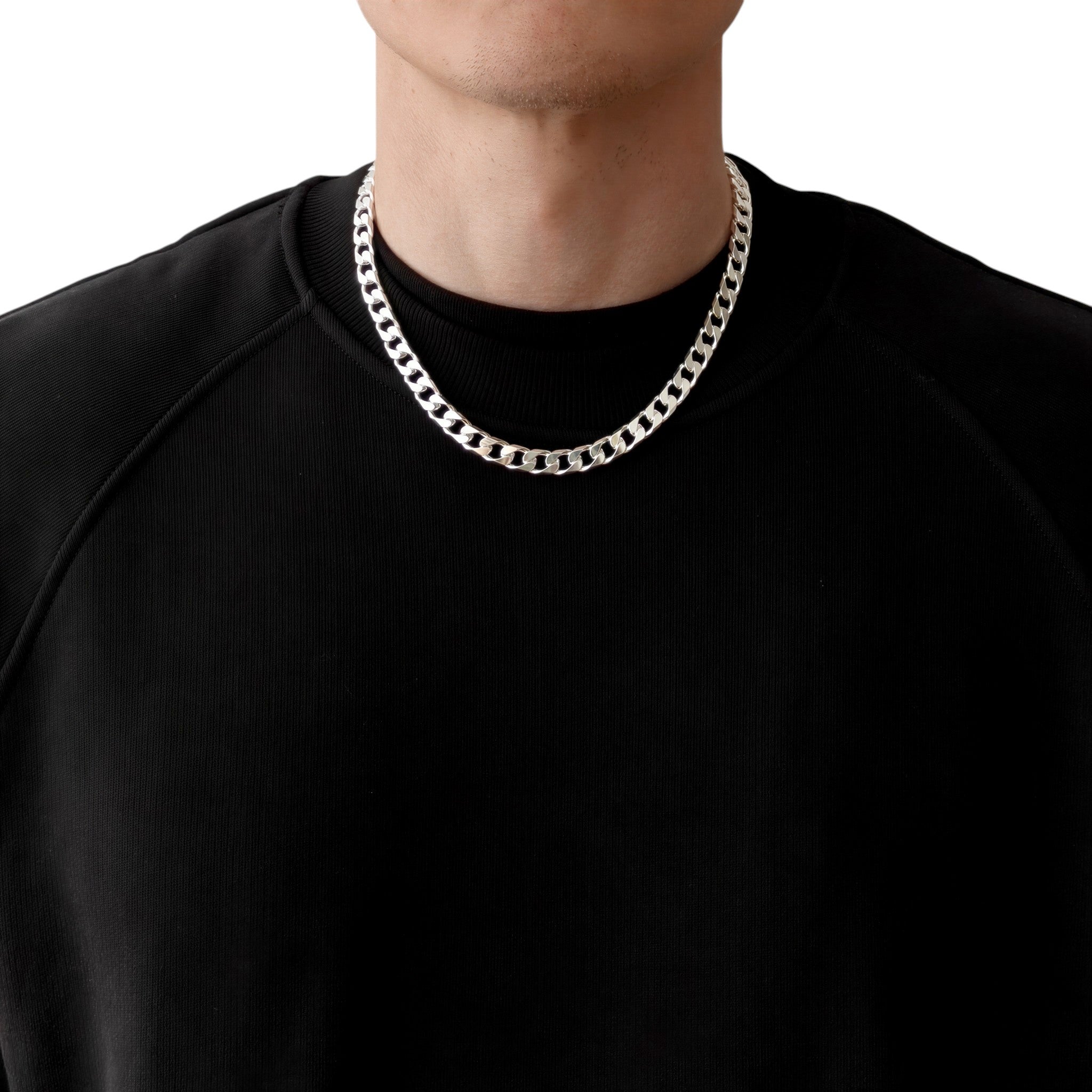 Neviera curb link chain necklace — Italian-made 925 sterling silver, 50cm length, 8,9mm width. Lifestyle photograph on model wearing the chain with a black crew-neck sweatshirt on a neutral background. Neviera specializes in high-quality Italian-made 925 silver chain necklaces and bracelets.