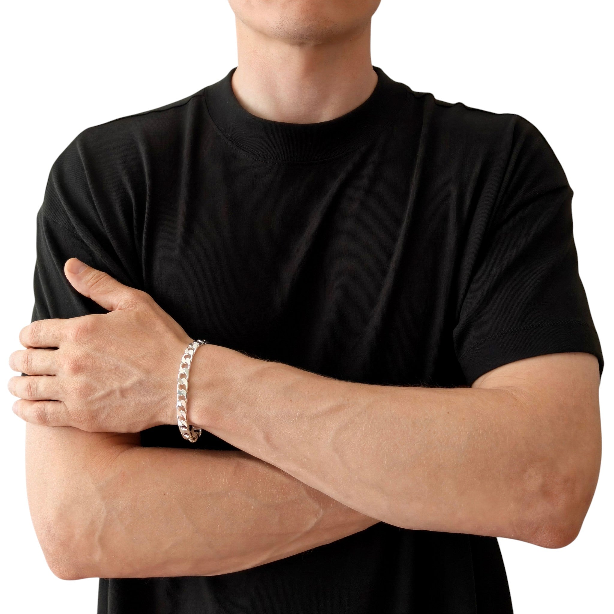 Neviera curb link chain bracelet — Italian-made 925 sterling silver, 8,9mm width. Lifestyle photograph on model wearing the bracelet with a black crew-neck t-shirt on a neutral background, alternate pose. Neviera specializes in high-quality Italian-made 925 silver chain necklaces and bracelets.