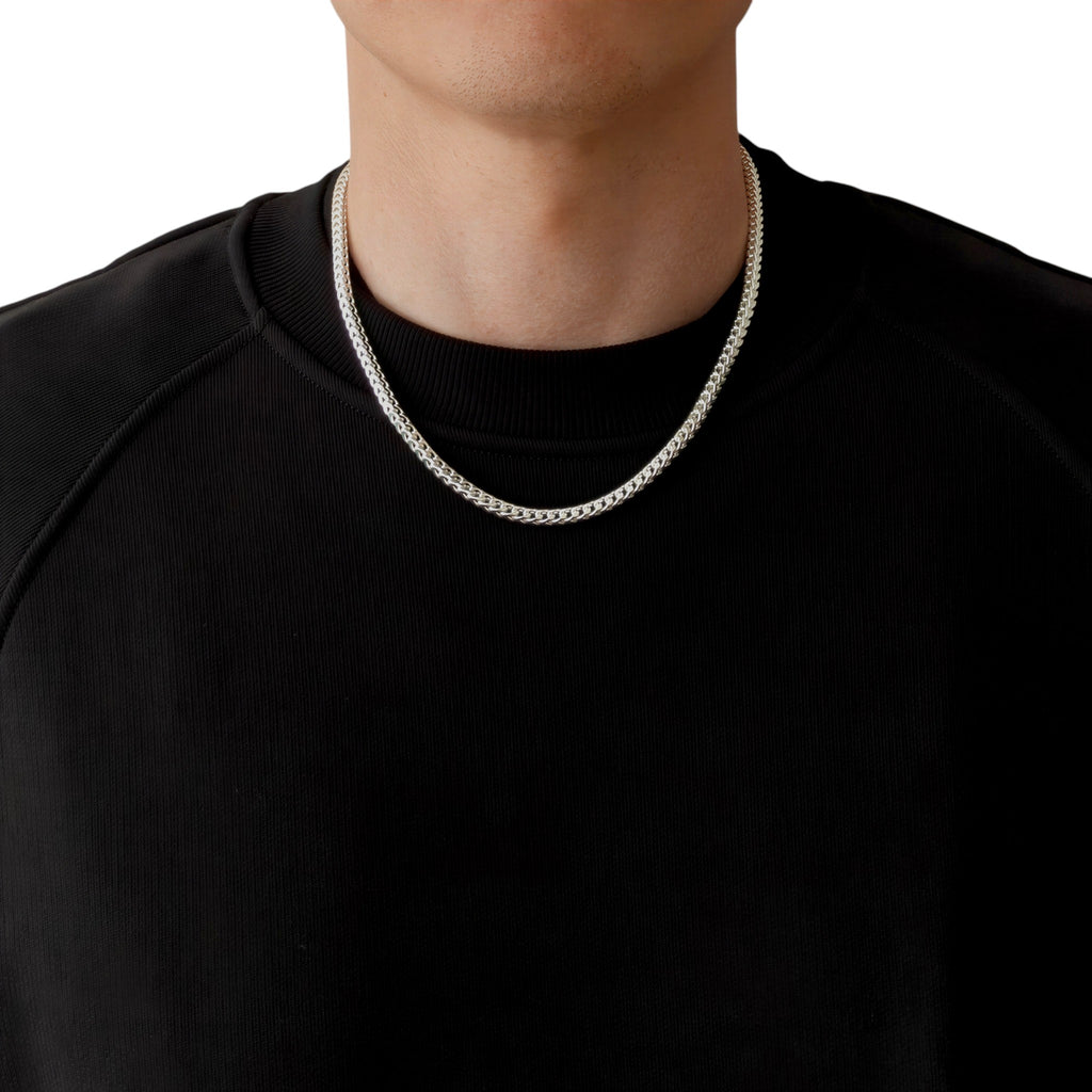 Neviera Franco chain necklace — Italian-made 925 sterling silver, 50cm length, 3,8mm width. Lifestyle photograph on model wearing the chain with a black crew-neck sweatshirt on a neutral background. Neviera specializes in high-quality Italian-made 925 silver chain necklaces and bracelets.