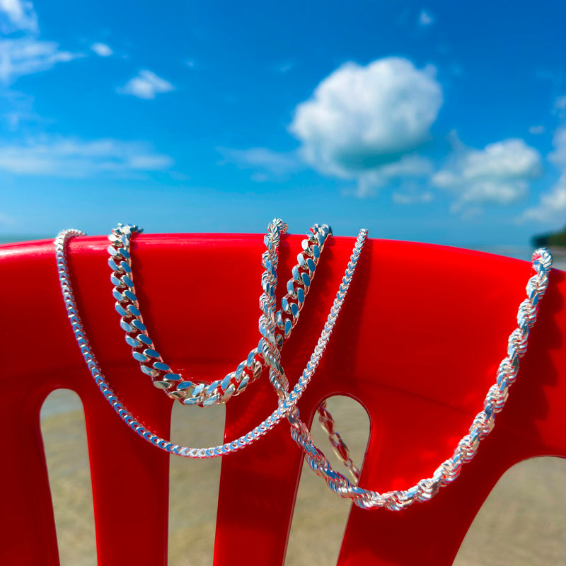 Various Neviera Silver Chains Hangin Against Red Plastic Chair